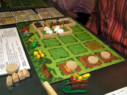 HD wallpaper of the board game Agricola with various game pieces arranged on a farming-themed play area.