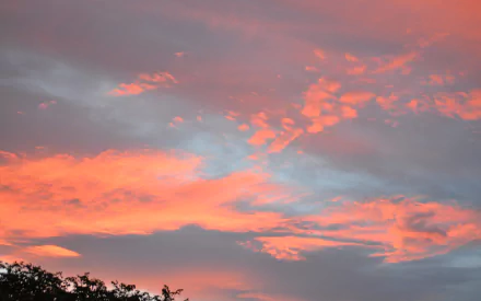 HD desktop wallpaper capturing a vibrant sunset sky with glowing clouds above a distant bushfire, blending natural beauty and environmental intensity.