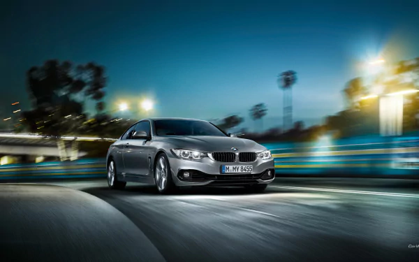 Silver BMW 4 Series Coupe vehicle speeding through lit city streets at night, motion-blurred HD PC desktop wallpaper/background.