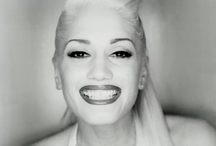 Black and white HD desktop wallpaper featuring a close-up of Gwen Stefani smiling, highlighting her iconic style and music influence.