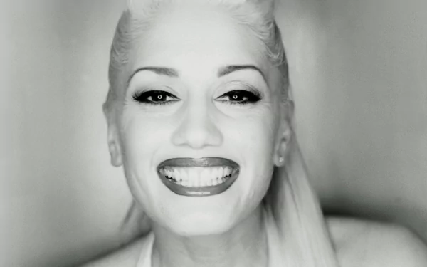 Black and white HD desktop wallpaper featuring a close-up of Gwen Stefani smiling, highlighting her iconic style and music influence.