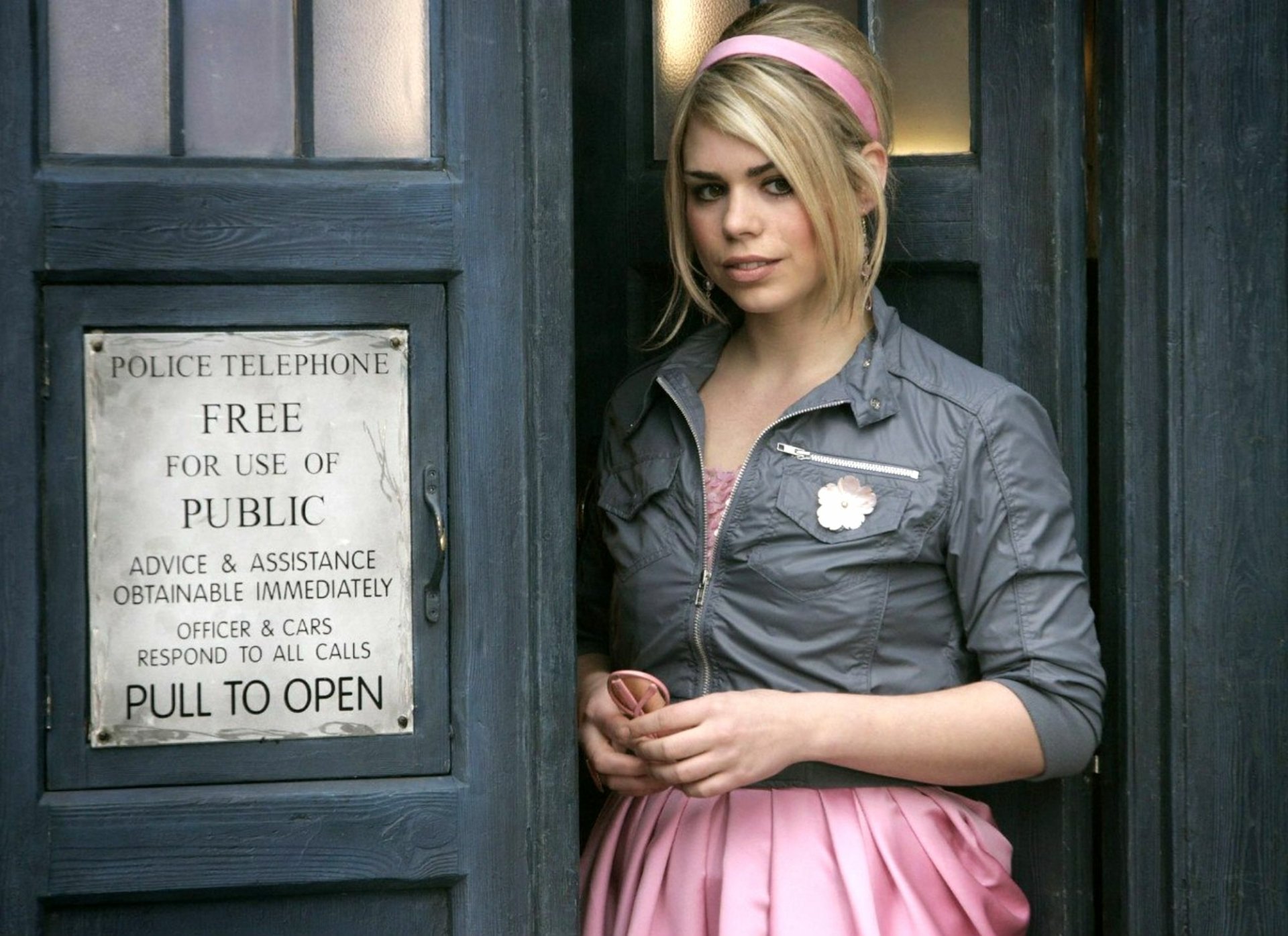A scene from the TV show Doctor Who (2005), featuring a character standing by the iconic TARDIS, set against a vibrant HD background.