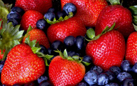 HD PC desktop wallpaper featuring a vibrant close-up of fresh red strawberries and dark blueberries, highlighting the texture and color of the berries.