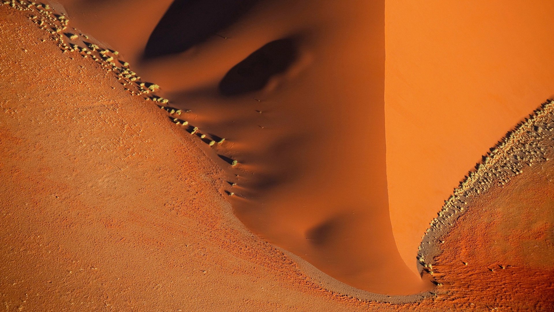 4K Ultra HD desktop wallpaper of a desert landscape showcasing smooth sand dunes and rocky textures under warm sunlight.