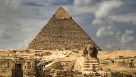 A stunning HD image of the Great Pyramid of Giza, showcasing its grandeur alongside the Sphinx, with dramatic skies enhancing the iconic Egyptian landscape.
