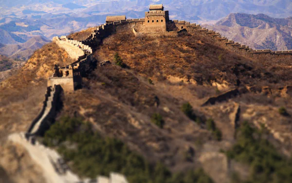 A stunning 4K Ultra HD image of the Great Wall of China winding through mountainous terrain, showcasing the remarkable man-made structure against a serene backdrop.