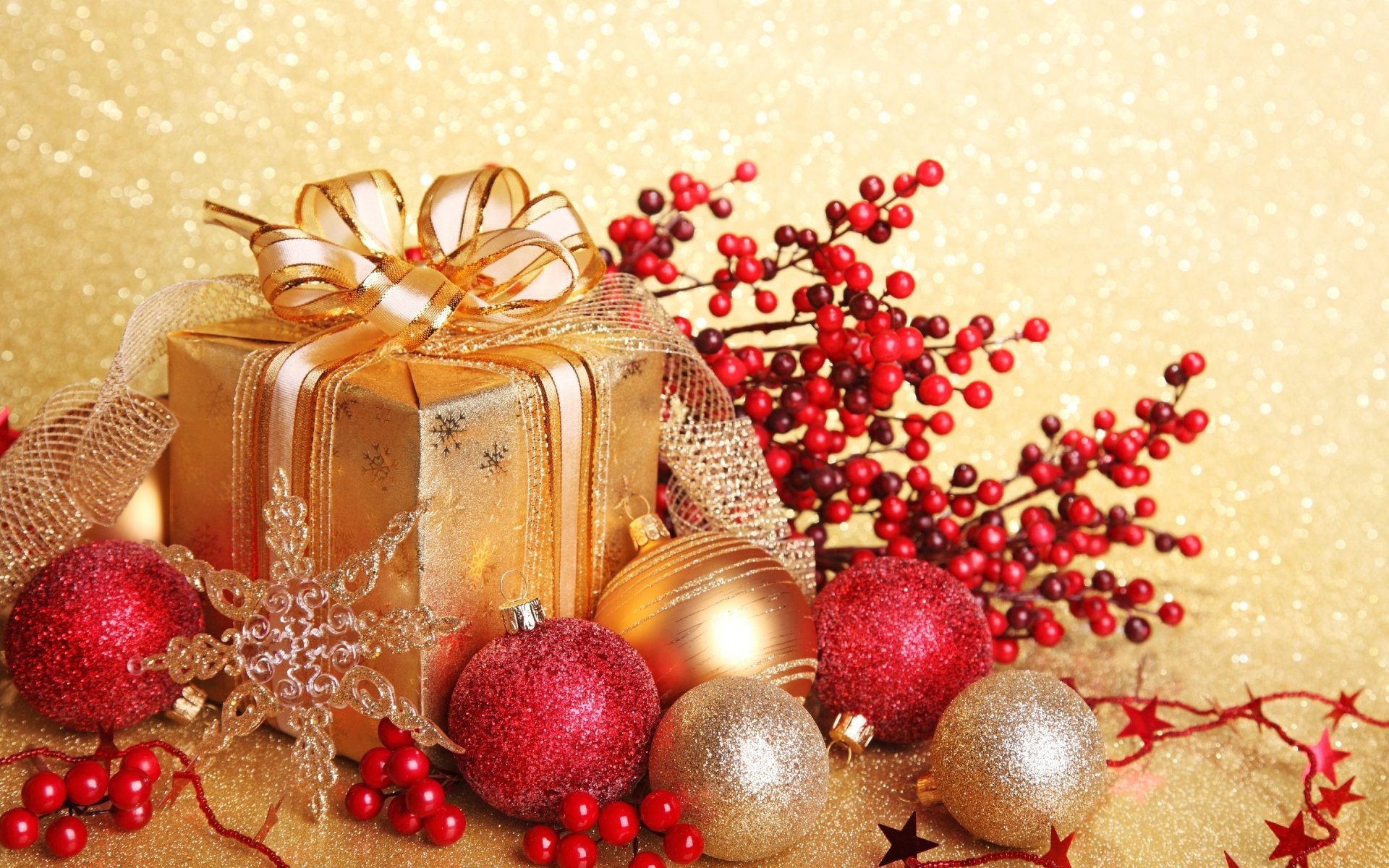 A beautifully wrapped golden gift surrounded by vibrant red and gold Christmas ornaments, festive greenery, and sparkling details against a shimmering gold background.