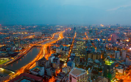 A vibrant time-lapse view of Ho Chi Minh City, featuring the Saigon River and illuminated streets showcasing the dynamic energy of urban Vietnam. HD wallpaper background.