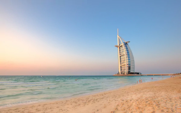 4K Ultra HD wallpaper showcasing the man-made Burj Al Arab against a clear sky, with the serene beach and calm sea in the foreground.