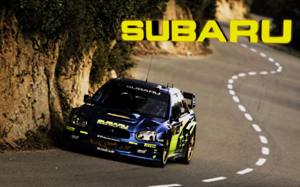 HD PC desktop wallpaper featuring a Subaru rally car speeding along a winding mountain road with cliffs in the background and bold yellow SUBARU text above.