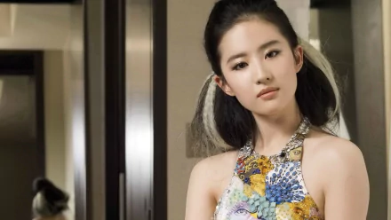 Liu Yifei, a Chinese actress, poses elegantly in a colorful dress, showcased in this HD desktop wallpaper, radiating a blend of grace and modern style.
