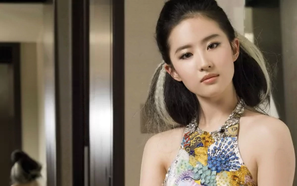 Liu Yifei, a Chinese actress, poses elegantly in a colorful dress, showcased in this HD desktop wallpaper, radiating a blend of grace and modern style.