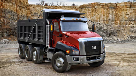 HD desktop wallpaper featuring a red Caterpillar Inc. dump truck in a rocky quarry setting.