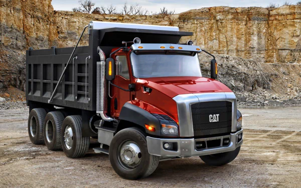 HD desktop wallpaper featuring a red Caterpillar Inc. dump truck in a rocky quarry setting.