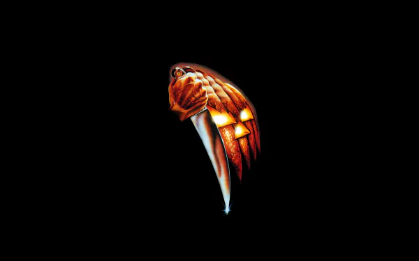 A striking 8K Ultra HD wallpaper featuring elements from the classic horror movie Halloween (1978), showcasing a menacing pumpkin face grasping a knife against a black background.