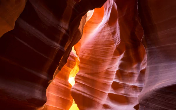 Sunlit sandstone slot canyon walls in Antelope Canyon glowing orange and purple — 4K Ultra HD nature canyon PC desktop wallpaper and background.