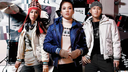 A stylish HD desktop wallpaper featuring three individuals, including the renowned Korean celebrity Song Hye Kyo, dressed in fashionable winter outfits against a dynamic background.