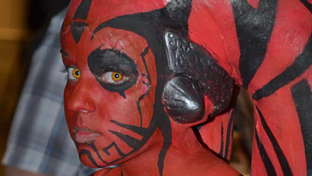 HD PC desktop wallpaper featuring a woman cosplaying as Darth Talon from Star Wars with detailed red and black face and body paint.