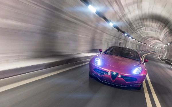 Red Alfa Romeo Disco Volante vehicle racing through a lit tunnel, motion-blurred 2K Quad HD PC desktop wallpaper background showcasing the car's front profile and headlights.