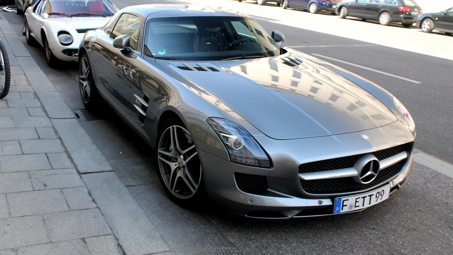 Silver Mercedes-Benz SLS AMG parked on a city street, captured in sharp detail for a 4K Ultra HD PC desktop wallpaper.