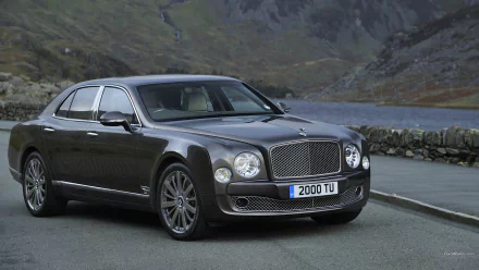 HD PC desktop wallpaper of a 2013 Bentley Mulsanne vehicle parked by a lakeside road with rugged mountains in the background.