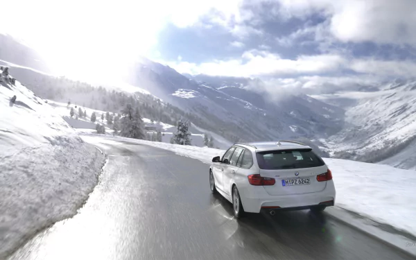 HD PC desktop wallpaper and background: a white 2013 BMW 320d driving on a wet mountain road through a snowy alpine landscape under a dramatic cloudy sky.
