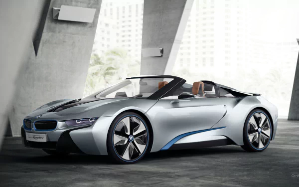 HD PC desktop wallpaper featuring a sleek silver BMW i8 Concept Spyder convertible parked indoors with modern architectural elements in the background.