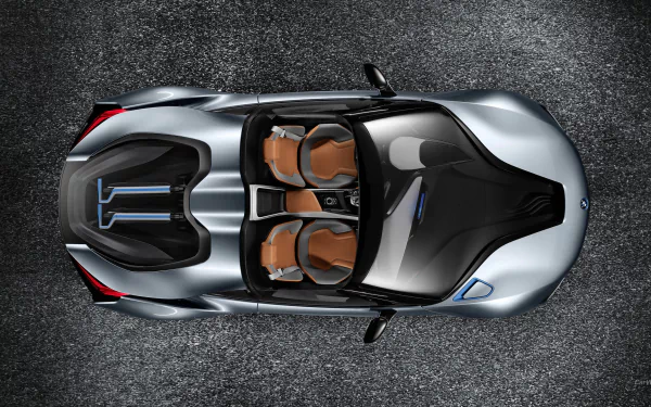 Top-down view of a silver BMW i8 Concept Spyder with tan leather seats on textured asphalt — HD PC desktop wallpaper/background.
