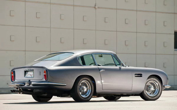 Silver Aston Martin DB6 classic vehicle parked before a tiled wall, rendered as an HD PC desktop wallpaper and background.