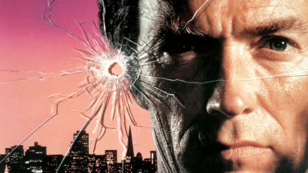 HD desktop wallpaper featuring Clint Eastwood's intense close-up from the movie Sudden Impact with a bullet hole cracked glass effect over a city skyline at sunset.