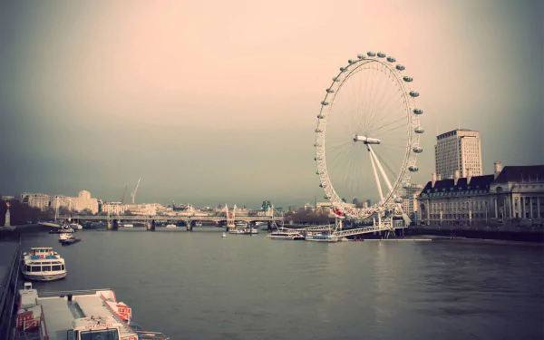 HD desktop wallpaper of the London Eye beside the River Thames, showcasing a man-made landmark against a soft, pastel sky in London.