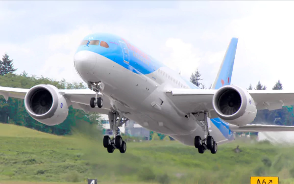 HD PC desktop wallpaper of a Boeing 787 Dreamliner aircraft taking off with landing gear extended over a grassy area under a partly cloudy sky.