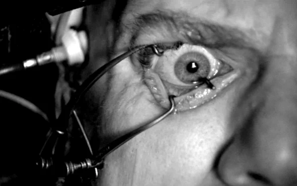 HD PC desktop wallpaper/background — black-and-white close-up from the movie A Clockwork Orange: an eye held open by metal clamps during a stark clinical procedure.