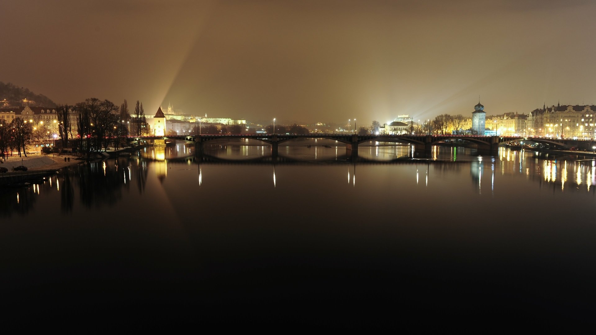Night view of Prague, Czech Republic: illuminated man-made bridges and historic riverside buildings reflected on the Vltava — 4K Ultra HD PC desktop wallpaper/background