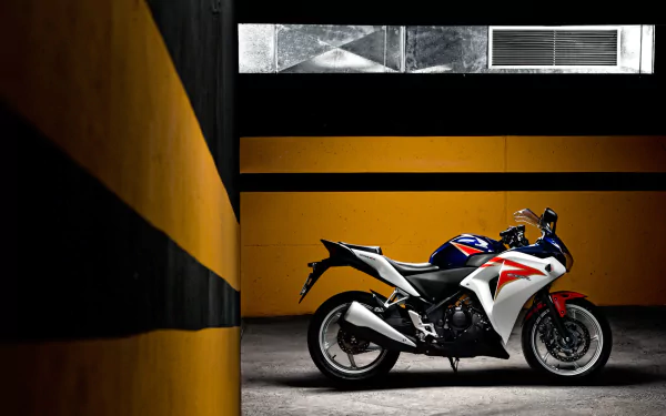A striking Honda CBR motorcycle displayed against a minimalist backdrop, showcasing its sleek design and vibrant colors, set in a stylish HD PC desktop wallpaper format.