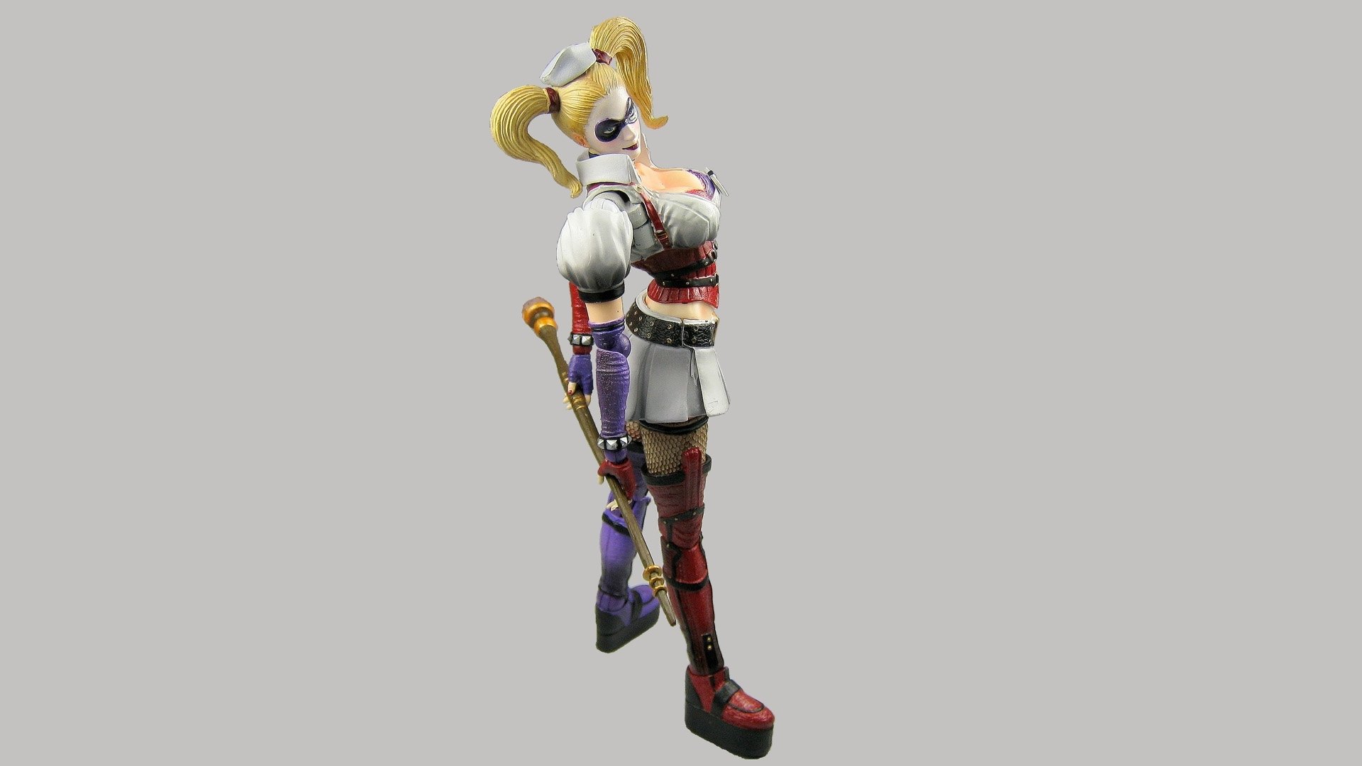 HD PC desktop wallpaper featuring Harley Quinn from the video game Batman: Arkham Asylum, showcasing her iconic colorful costume and playful pose.