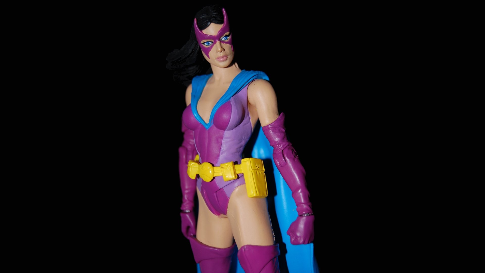 Huntress (DC Comics) figurine in purple and blue costume with yellow utility belt against a black background — 5K Ultra HD PC desktop wallpaper of a comic collectible toy.
