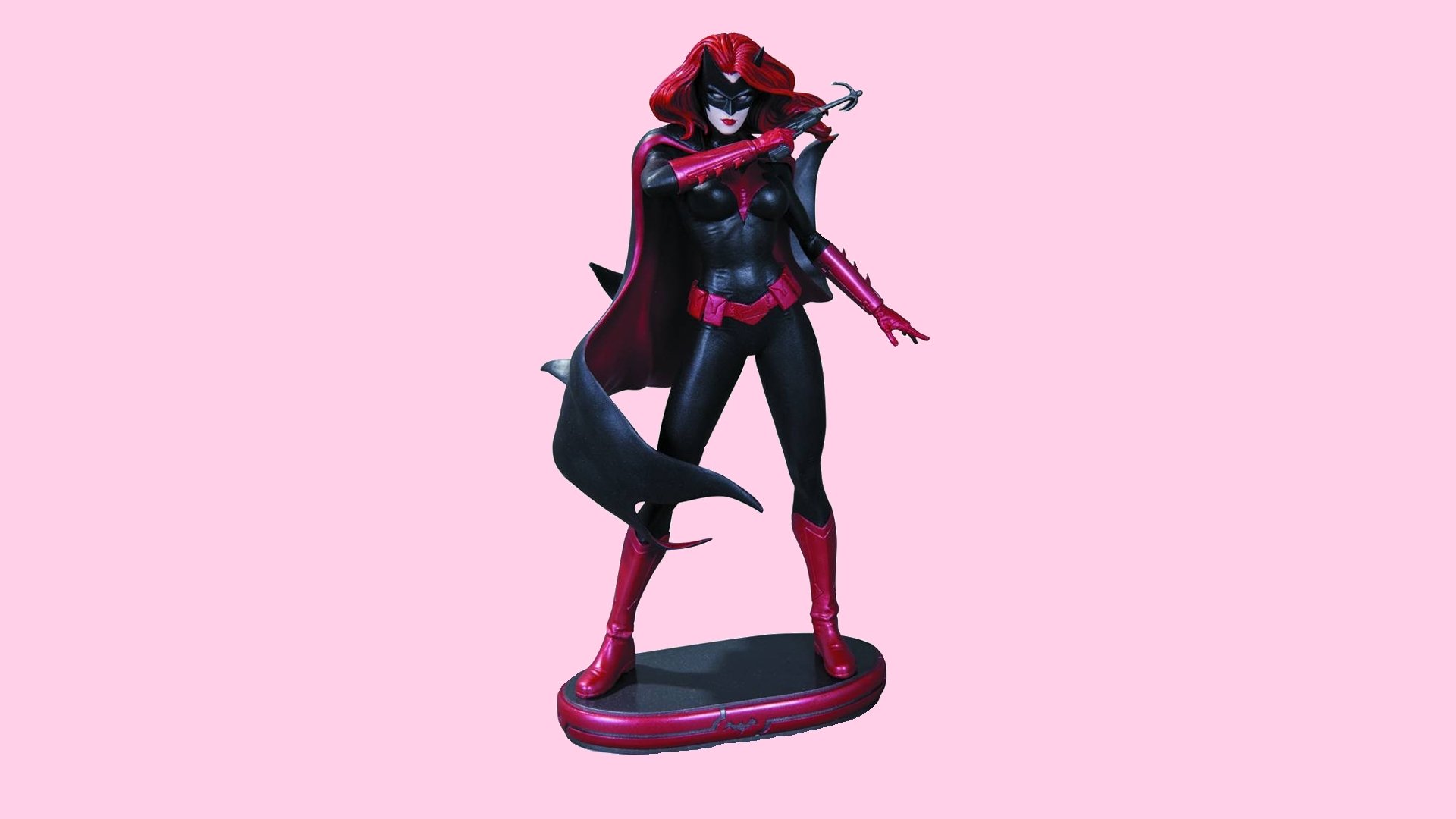 HD comic-style wallpaper featuring Batwoman in a dynamic pose with red and black costume against a solid pink background, designed for PC desktops.