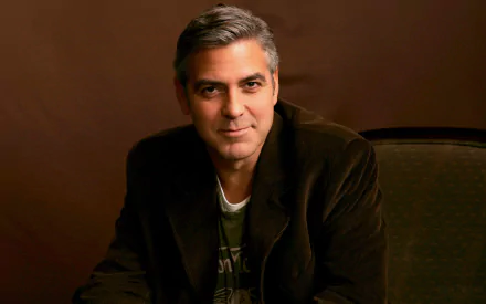 HD PC desktop wallpaper featuring a portrait of celebrity George Clooney against a warm brown background.