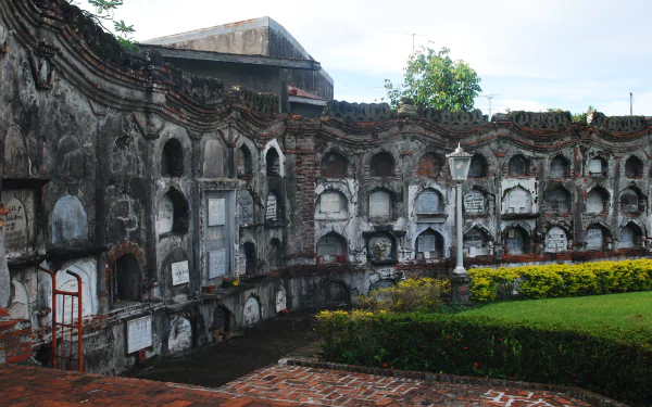 4K Ultra HD wallpaper of a historic man-made architectural structure featuring weathered stone walls with arched niches and a well-maintained garden in front.