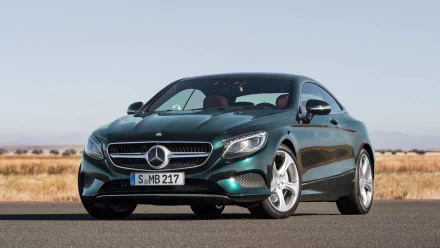 HD PC desktop wallpaper showing a Mercedes-Benz S-Class Coupe vehicle in three-quarter front view on an open road, with prominent Mercedes-Benz badge and grille.