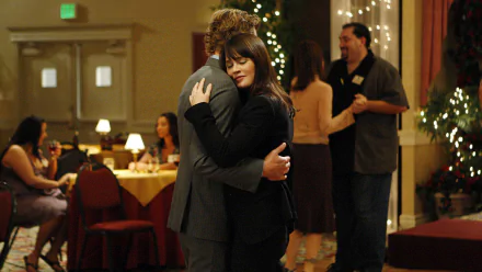 Teresa Lisbon and Patrick Jane, characters from The Mentalist TV show played by Robin Tunney and Simon Baker, share a warm embrace at a festive gathering.