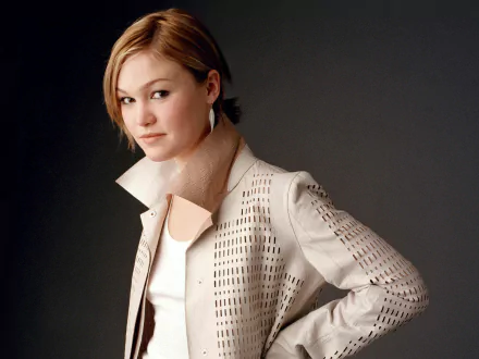 A stylish Julia Stiles poses confidently in an elegant jacket, captured for a high-definition desktop wallpaper. The image showcases her contemporary fashion sense and striking presence.
