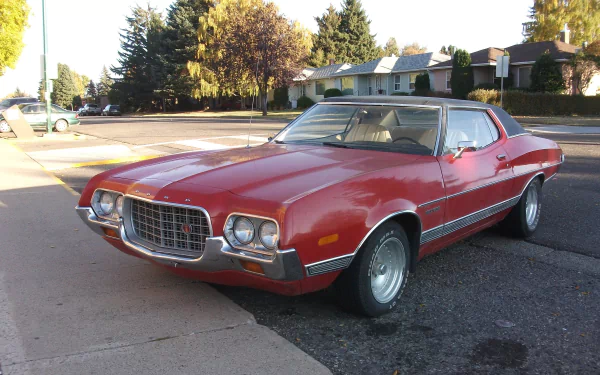 A classic Ford Gran Torino parked on the street, showcasing its distinctive design and vibrant red color, making for a striking HD PC desktop wallpaper and background.