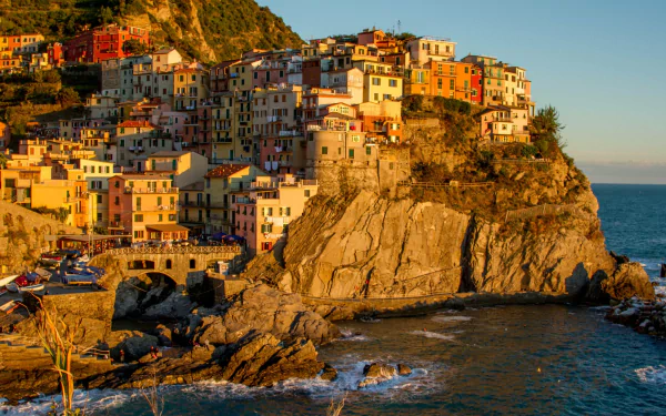 A vibrant man-made village of Manarola perched on rugged cliffs by the sea, captured in stunning 4K Ultra HD detail for a PC desktop wallpaper.
