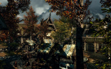 HD PC desktop wallpaper from the video game The Elder Scrolls V: Skyrim, featuring a detailed autumn village scene with houses and trees under a cloudy sky.