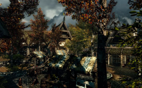 HD PC desktop wallpaper from the video game The Elder Scrolls V: Skyrim, featuring a detailed autumn village scene with houses and trees under a cloudy sky.