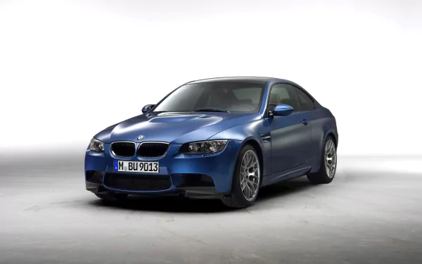 HD PC desktop wallpaper featuring a blue BMW M3 Competition parked on a smooth, light gray surface against a white background.