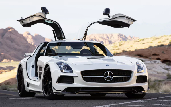 White Mercedes-Benz SLS AMG with gullwing doors open, set against a rocky desert landscape, featured as an HD PC desktop wallpaper and background.