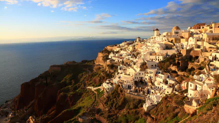 4K Ultra HD view of Santorini, Greece, showcasing iconic whitewashed buildings and a windmill perched on cliffs overlooking the Aegean Sea.